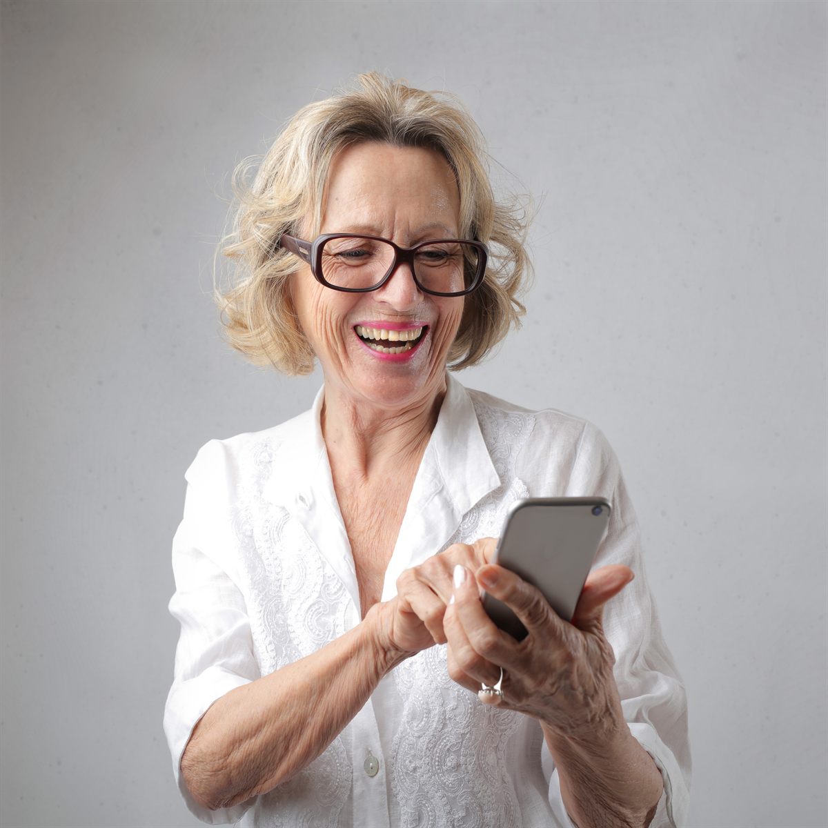 Person smiling while using a smartphone at home