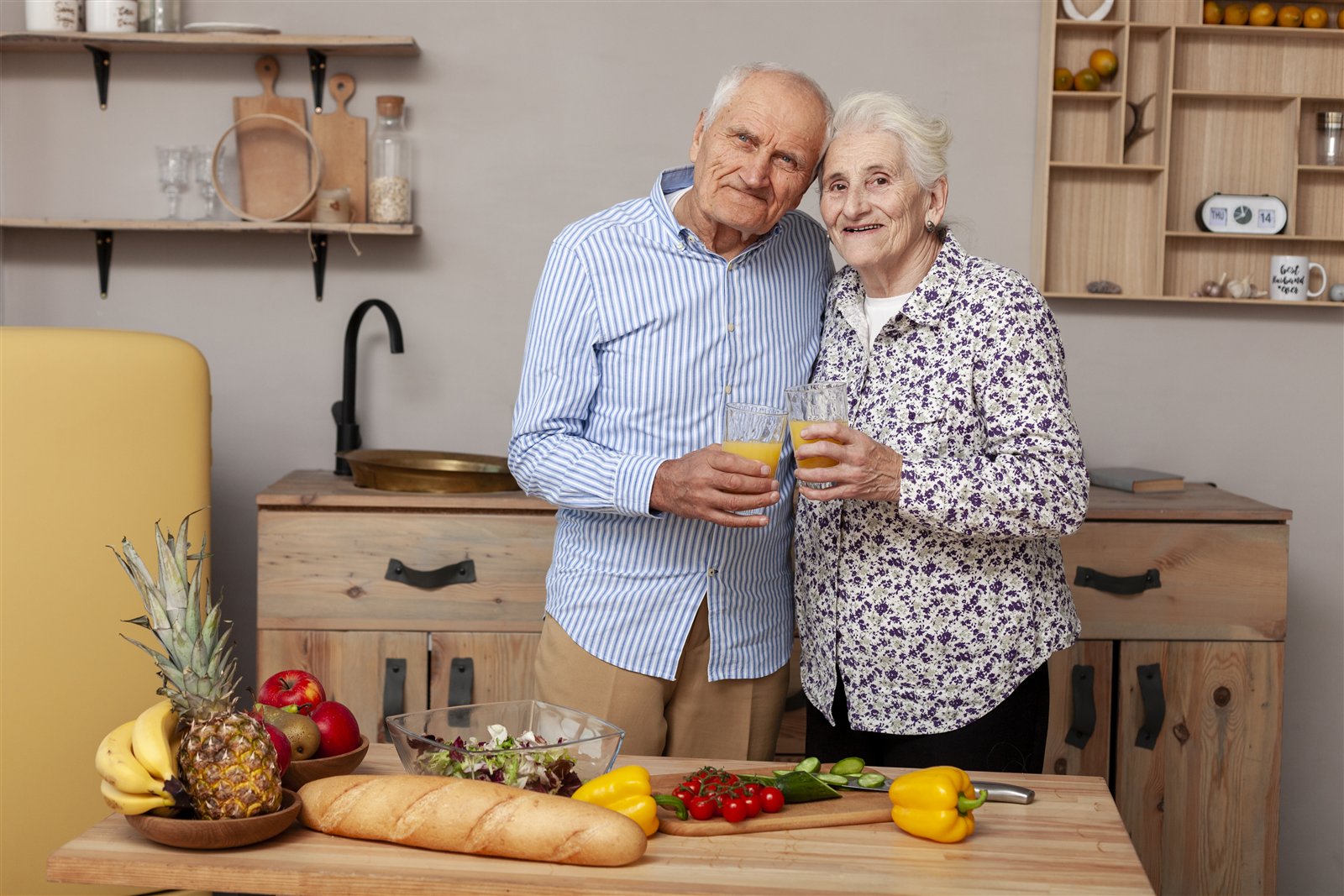 Older couple standing together in a bright kitchen after home support